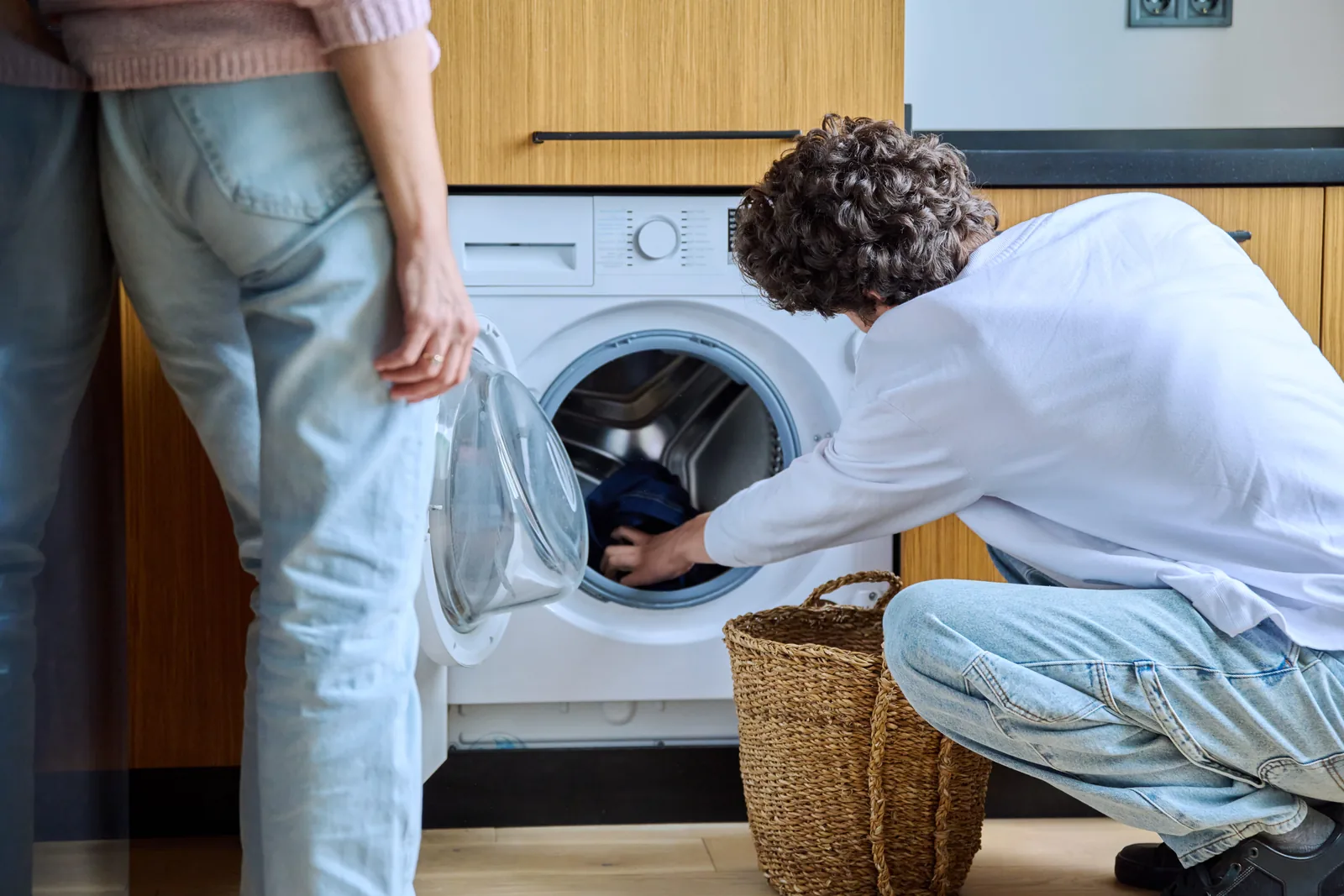 Couple loading laundry at home with their machines working reliably